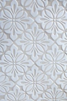 a close up view of a white wallpaper with flowers on the back and sides