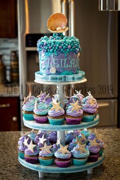 three tiered cake with cupcakes on top