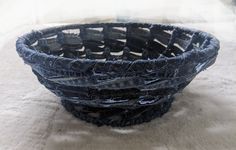 a blue basket sitting on top of a white blanket next to a glass tablecloth