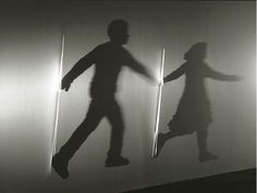 the shadow of a person and a child on a wall