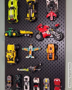 there are many toy cars and trucks on the pegboard