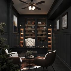 a living room with two chairs and a table in front of a book shelf filled with books