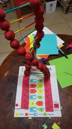 a wooden table topped with lots of crafting supplies and paper on top of it