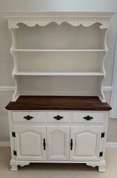 a white dresser with wooden top and drawers