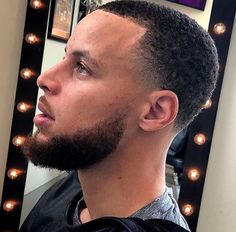 a close up of a person with a hair brush in front of a mirror and lights