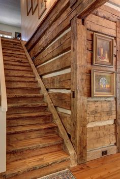 a wooden staircase with pictures on the wall