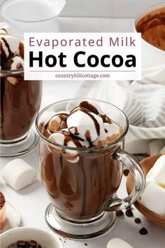 hot cocoa in a glass mug with marshmallows and chocolate on the side