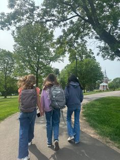 three girls walking down a path in the park