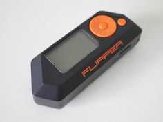 an orange and black electronic device sitting on top of a white table with the word flupper written on it