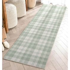 a large rug in the middle of a room with white and green plaid patterns on it