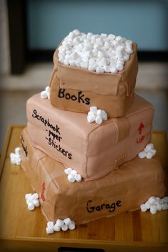 this is a cake made to look like suitcases with books written on them and marshmallows around the edges