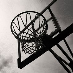 a basketball hoop is shown in black and white, with the sky in the background