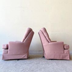 two pink couches sitting next to each other on the floor in front of a white wall