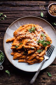 a white plate topped with pasta covered in sauce and parmesan sprinkles