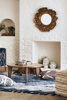 a living room filled with furniture and a fire place next to a white brick wall