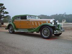 an antique car is parked on the side of the road