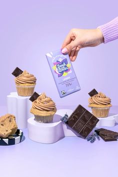 a person is pouring chocolate into some cupcakes and muffins that are stacked on top of each other