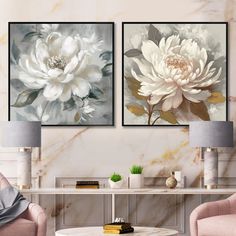 two large white flowers are on the wall in this living room with pink chairs and a marble coffee table