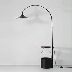 a black floor lamp next to a white wall