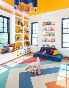 a living room with brightly colored carpeting and lots of bookshelves on the wall