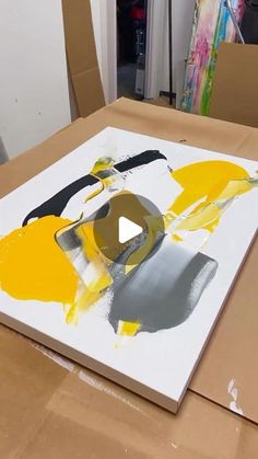 a painting is being displayed on top of a cardboard box in an art class room