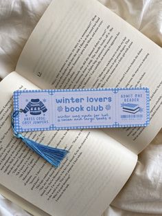 an open book with a blue tassel on top of it next to another book