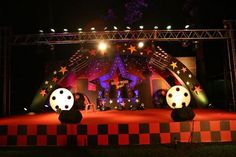 an outdoor stage set up for a concert with stars and stripes on the front, black and white checkered backdrop