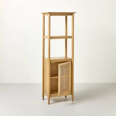 a wooden shelf with a wicker basket on the bottom and shelves below it, against a white wall