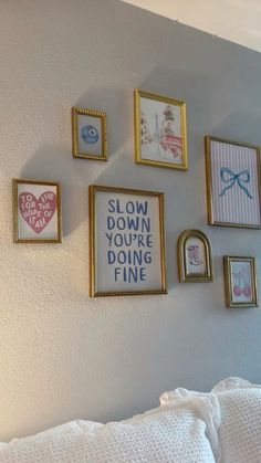 there are many framed pictures on the wall next to each other, including one that says slow down you're doing fine