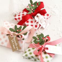 three christmas gift boxes with bows and tags on them