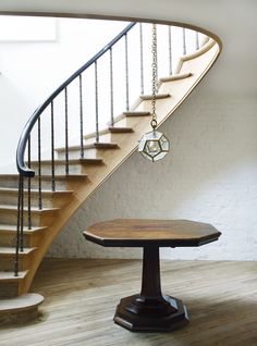 a wooden table sitting in front of a stair case