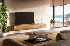 a living room filled with furniture and a flat screen tv on top of a wall