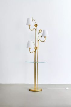 a lamp that is on top of a glass table next to a white wall and floor