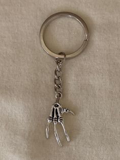 a metal keychain with a hand on it's side and two hands in the middle