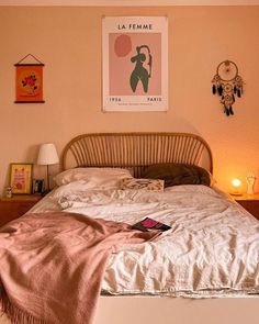 a bed in a bedroom with pink walls and pictures on the wall