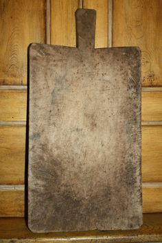 an old metal cutting board sitting on top of a wooden table next to a door