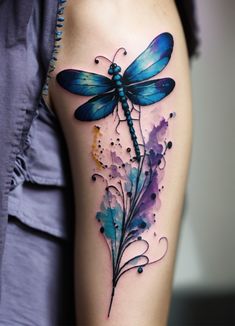 a woman's thigh with a blue dragonfly tattoo on it