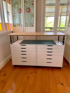 a white cabinet with drawers and a green mat on the bottom shelf next to it