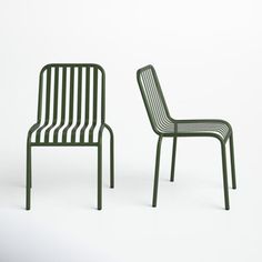 two green chairs sitting next to each other on a white surface with no one in it