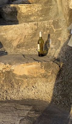 an empty bottle sitting on top of some rocks