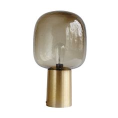 a glass and brass table lamp on a white background in the shape of a sphere