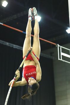 a woman in red shorts doing a high jump