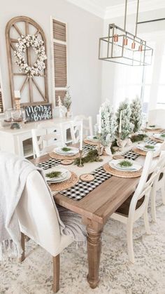 the dining room table is set with white chairs and black and white checkered placemats