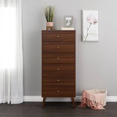 a chest of drawers next to a window