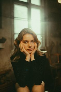 a woman sitting down with her hands on her face