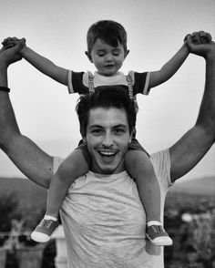 a man holding a child on his shoulders