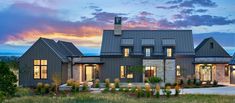 a large house with lots of windows on the front and side of it at dusk