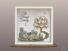 the family is made out of rocks and has a tree with hearts on it, surrounded by butterflies