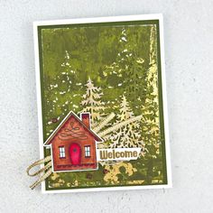 a handmade card with a house and trees in the background that says welcome on it