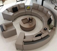 a large circular couch sitting on top of a white floor next to a coffee table